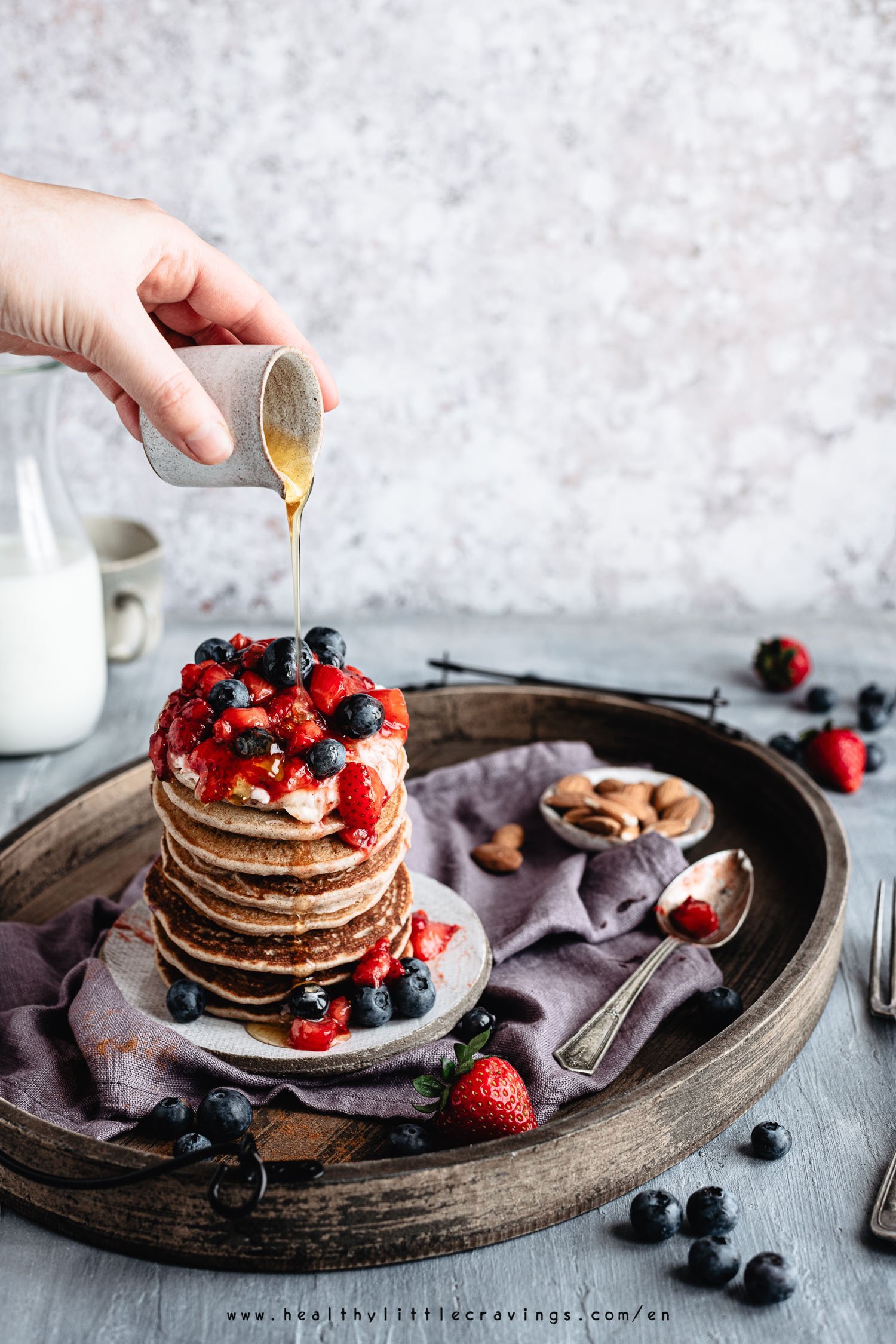 Vegan buckwheat pancakes stacked and topped with fruit 