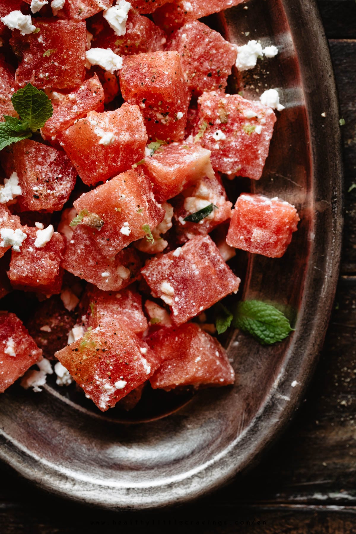 closeup of watermelon salad with feta on an oval plate