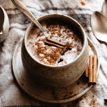 A mug full of pumpkin spice latte and cinnamon on top.