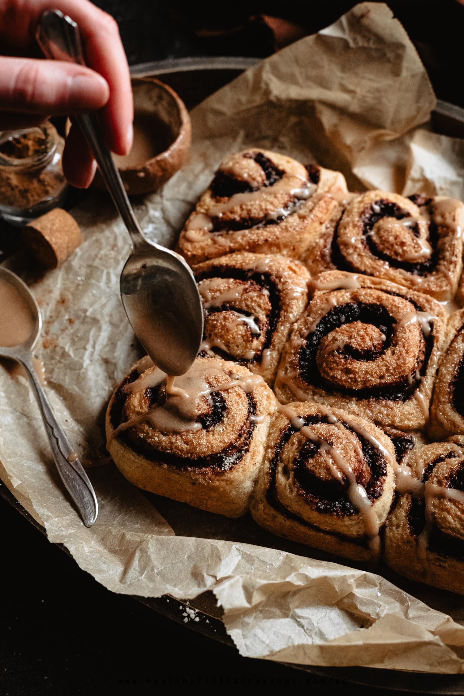 Drizzling some maple glaze on top of cinnamon rolls