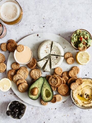 Healthy super bowl snacks: crackers served onto a marble platter with cheese and avocado