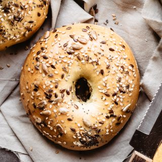 Single bagel with seeds on top, on a napkin