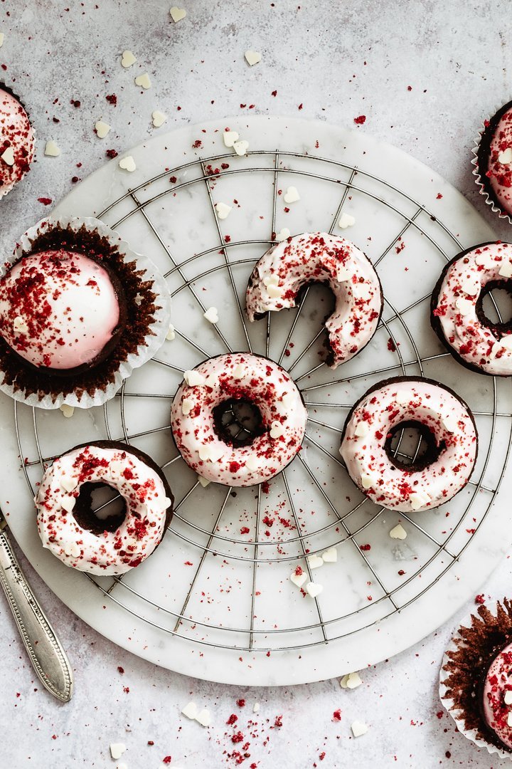 Red velvet cupcake recipe and donuts cooling on a marble base 