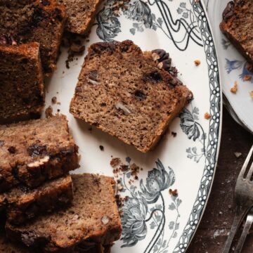 A slice of moist banana bread with nuts.