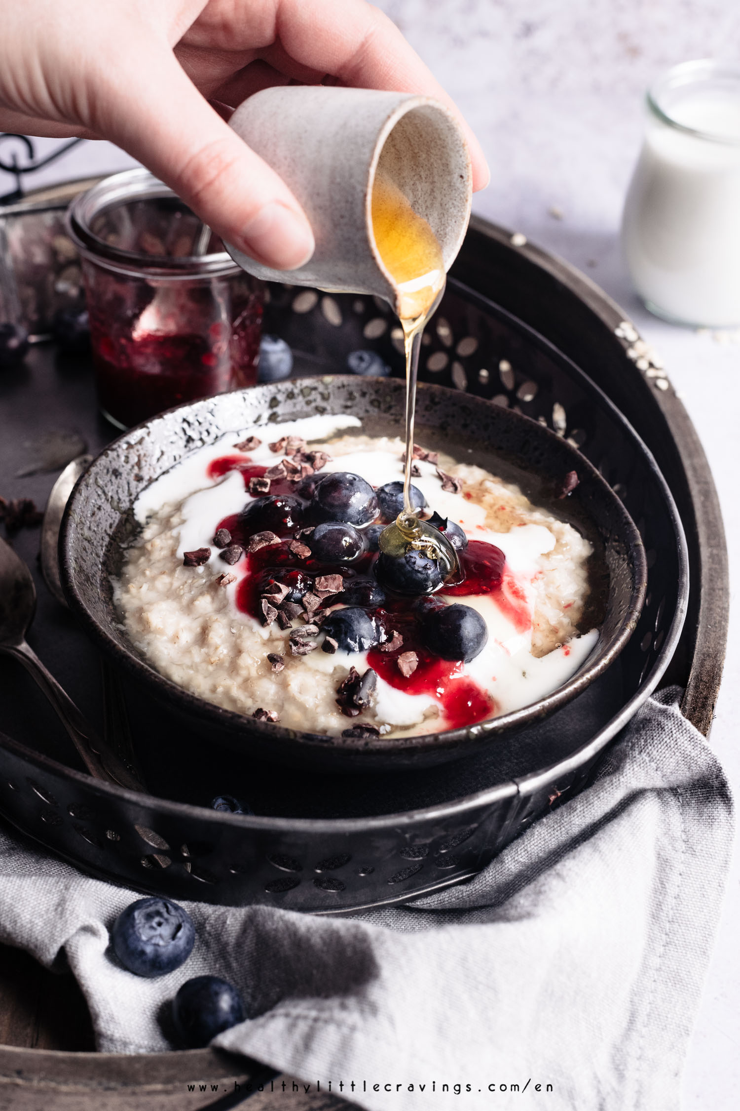 Honey dripping from jug onto oatmeal