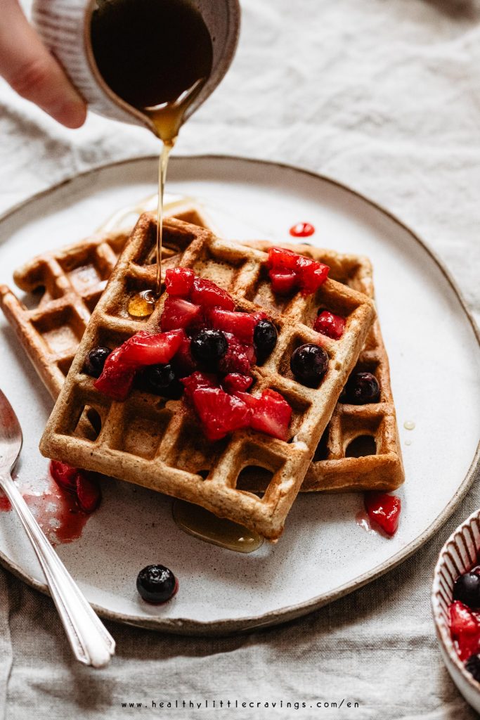 Drizzling maple syrup on top of waffles