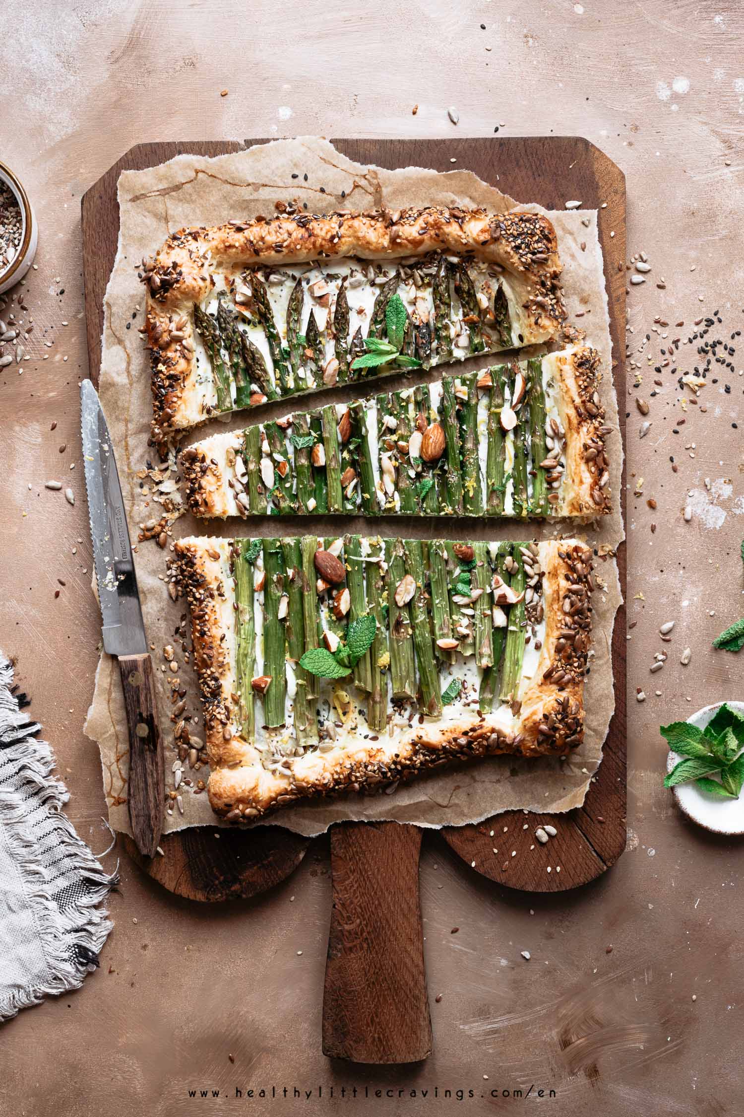 Slices of asparagus ricotta tart with almonds and mint