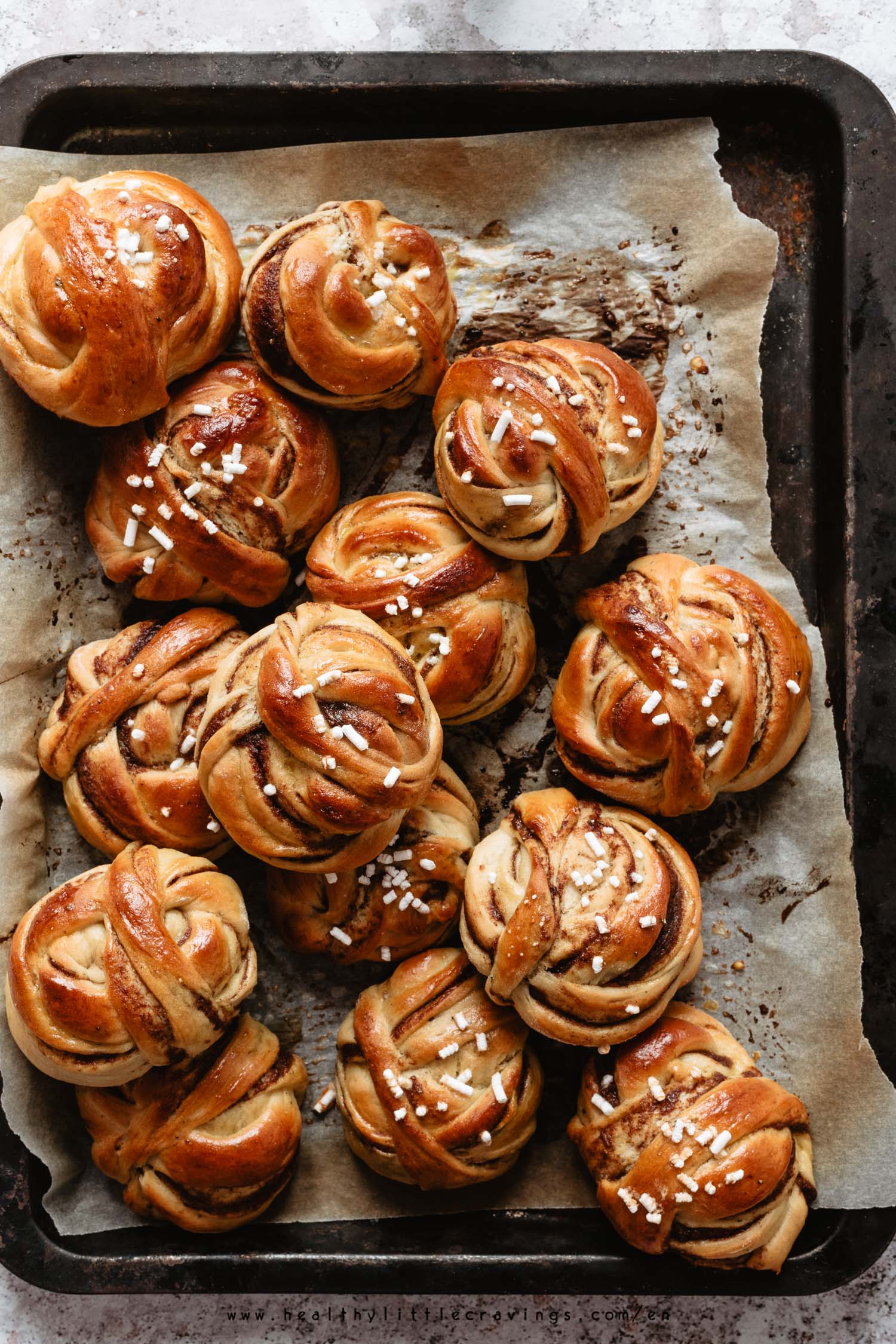 Swedish cardamom buns on parchment paper a baking tray