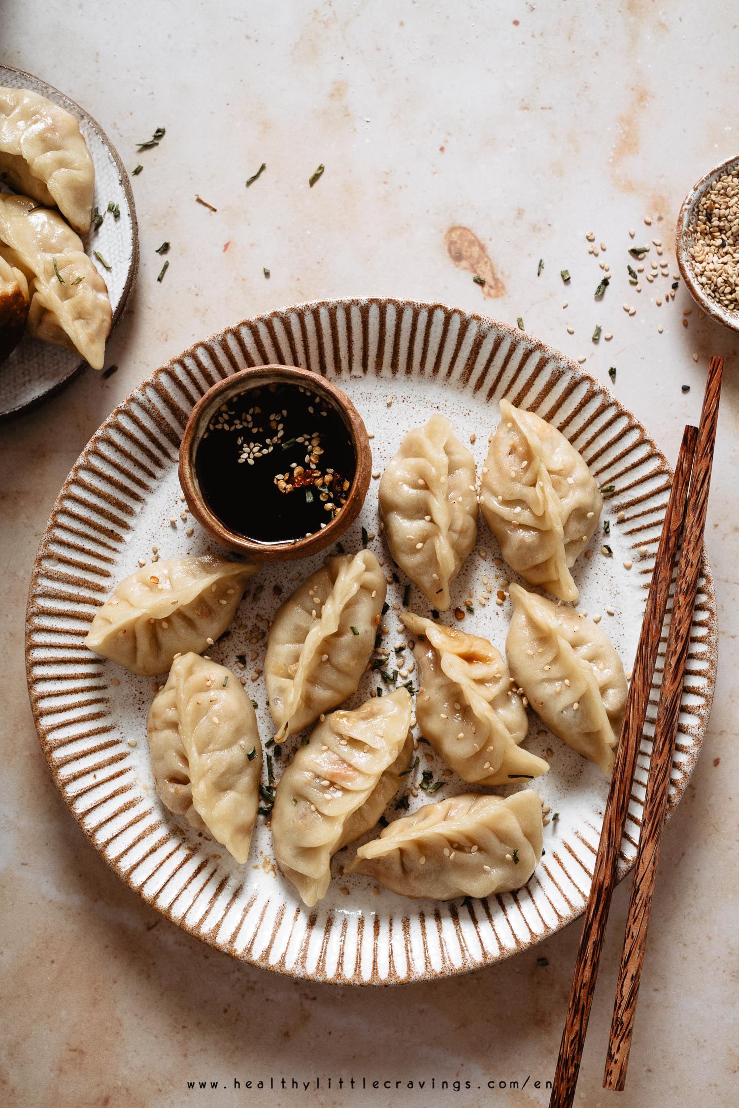 Chicken potstickers on a dish with a mini bowl of dipping sauce