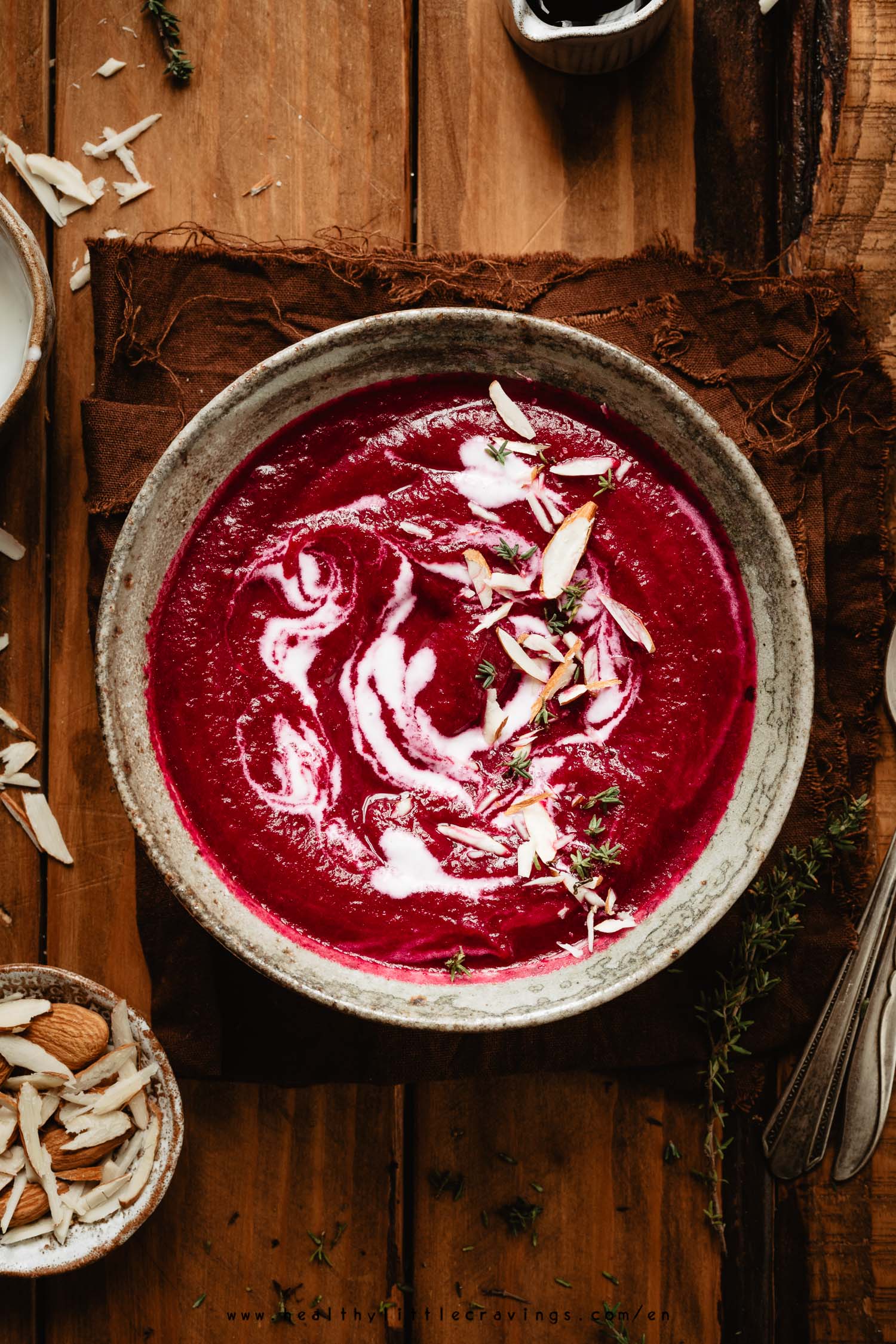 A beet soup into a bowl on a wooden table