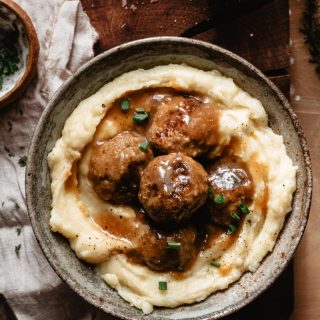 Easy Swedish meatballs into a bowl with mashed potatoes