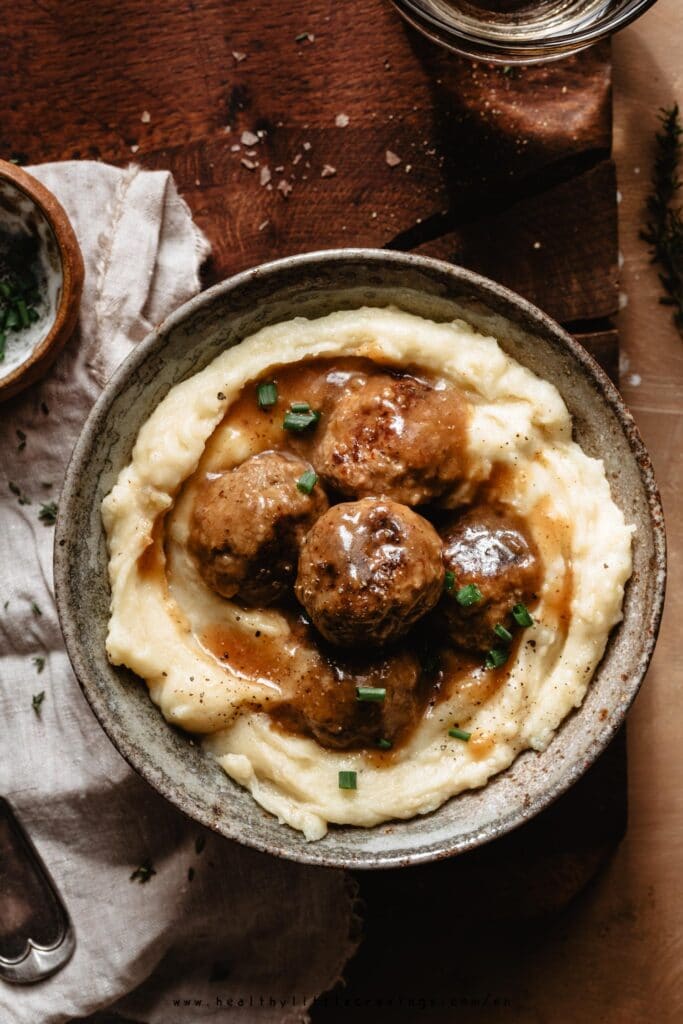 Easy Swedish meatballs into a bowl with mashed potatoes