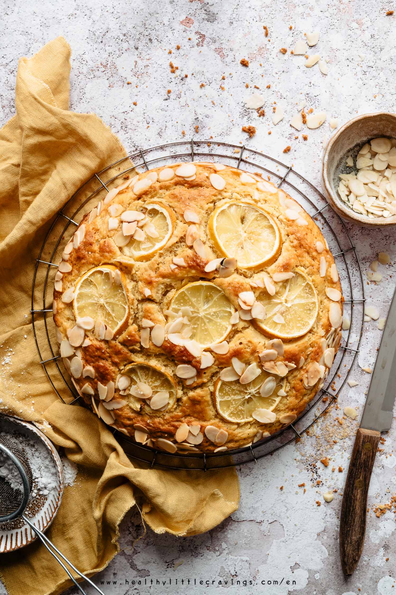 Lemon ricotta cake on a cooling rack with yellow napkin