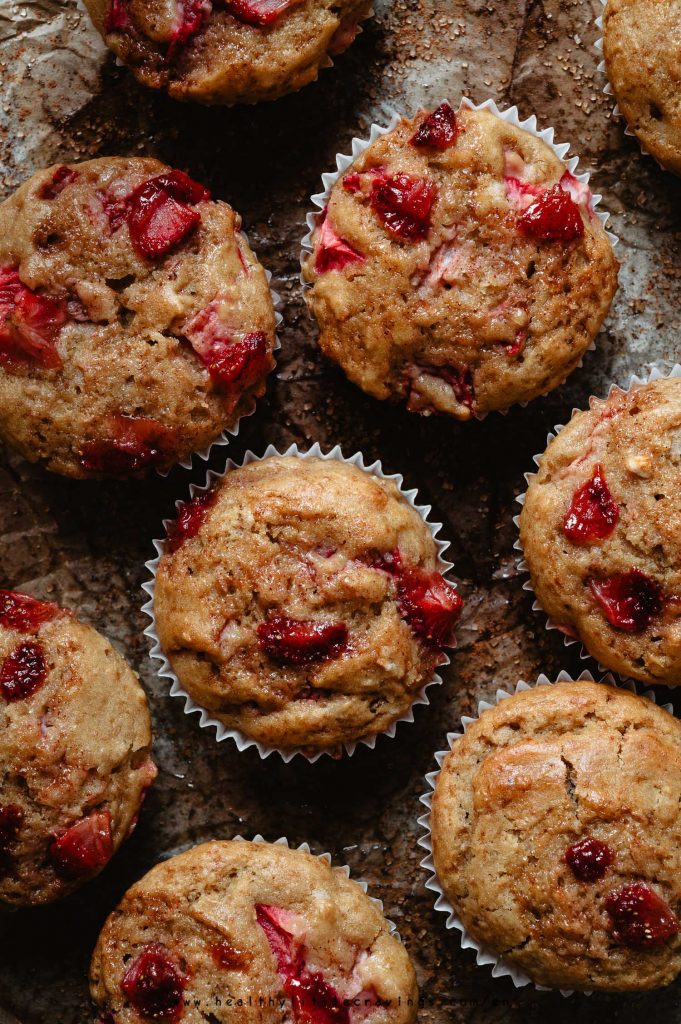 Multiple strawberry muffins on parchment paper