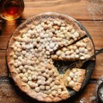 A bourbon pear pie with a glass of the bourbon on the side.