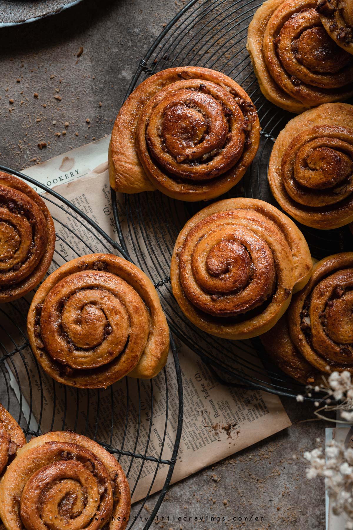 multiple cinnamon pumpkin rolls with bourbon-marinated pecans on cooling racks