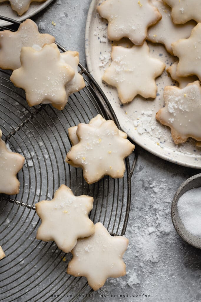 Lemon shortbread cookies on a cooling rack and a plate.