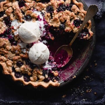 Blueberry crumble pie with vanilla ice cream on top.